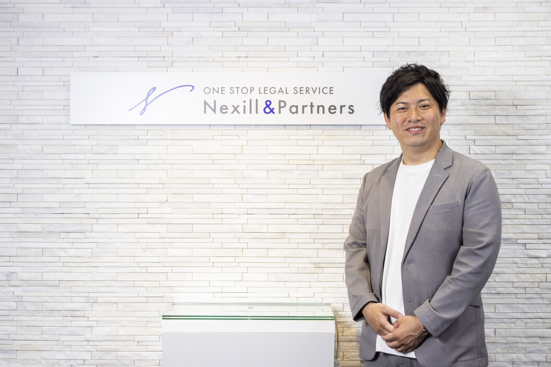 事務所エントランスと菰田代表弁護士