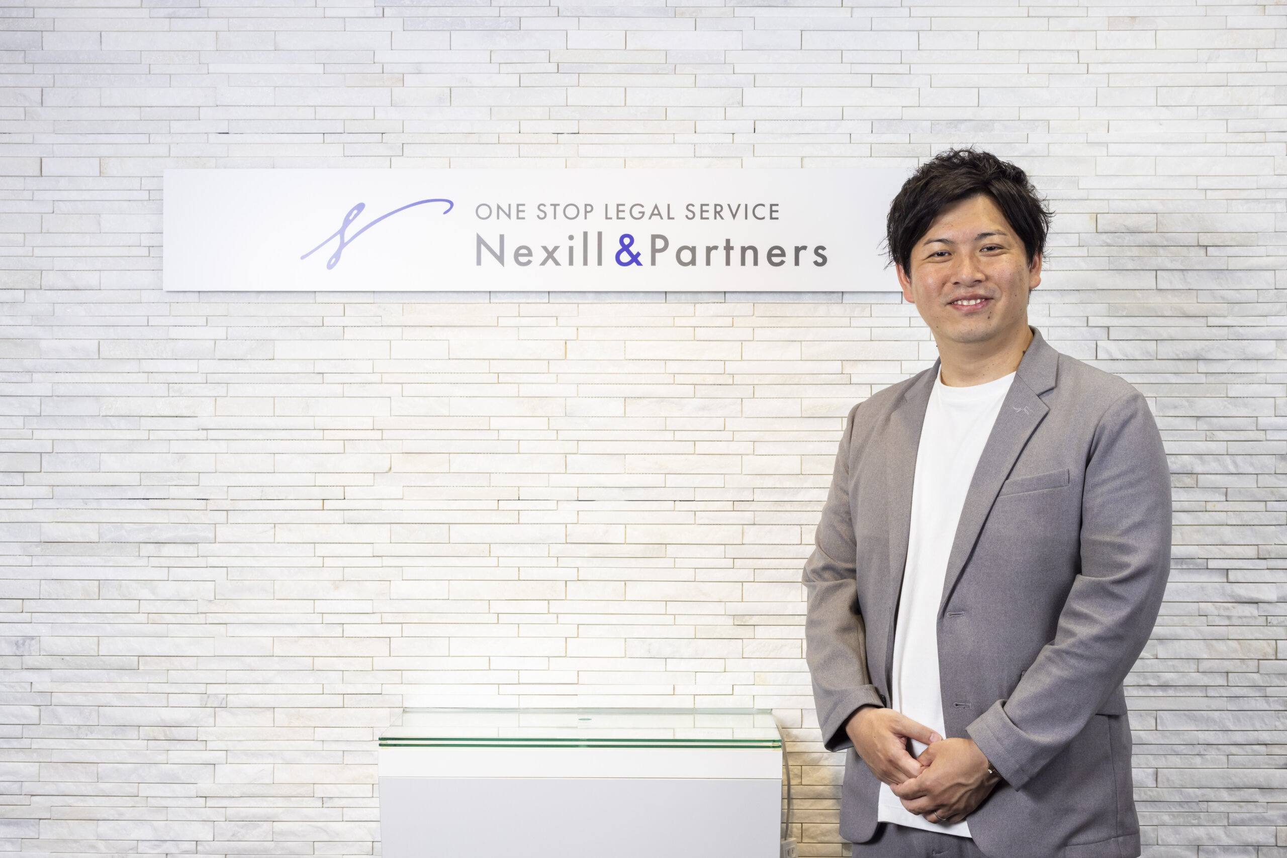 事務所エントランスと菰田代表弁護士